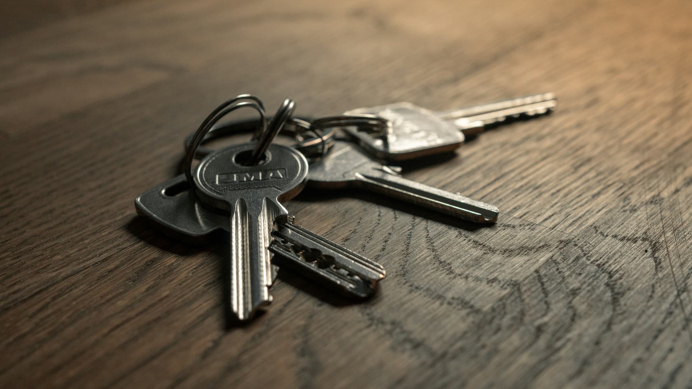 Room keys on a dark wooden reception desk.